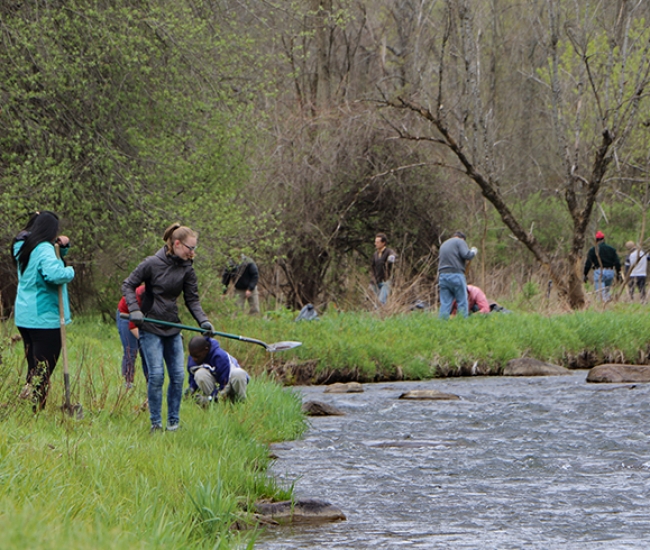 Students in foreground adults in background along river