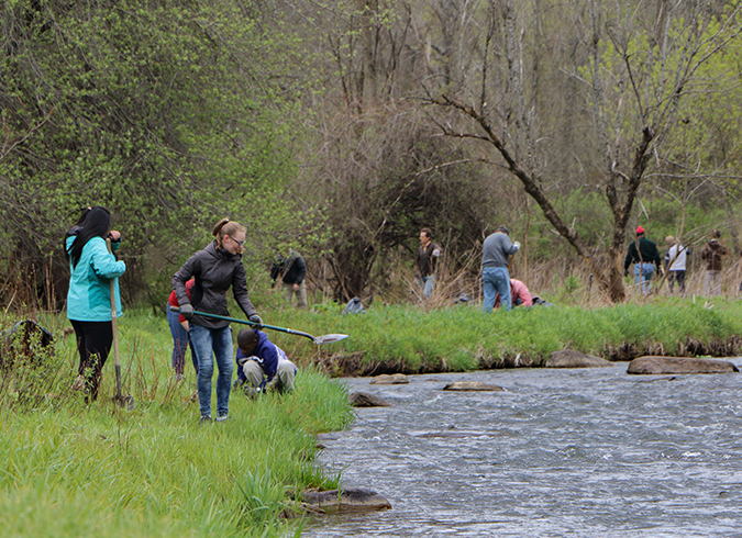 Students in foreground adults in background along river